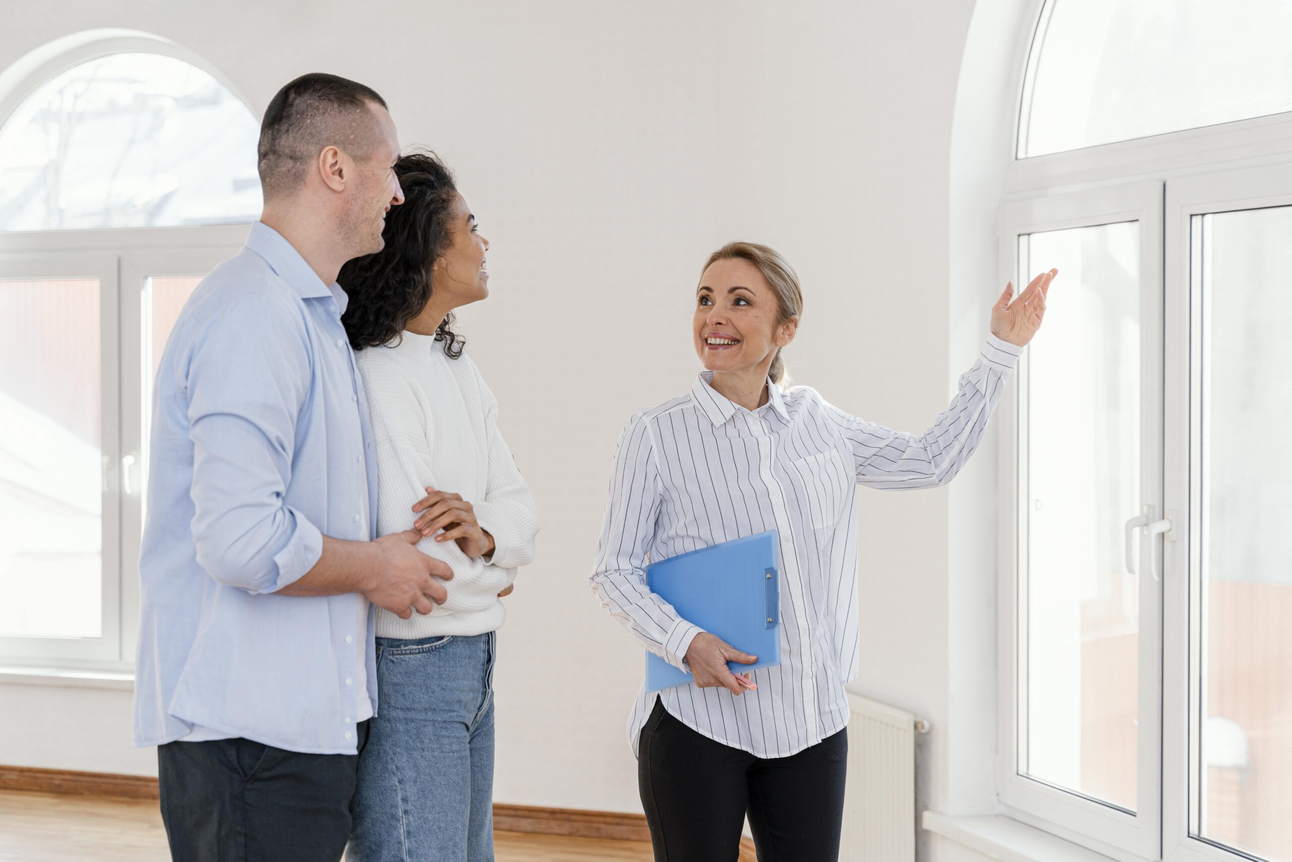 Real estate agent showing a property to a couple in the UK